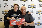 Izza Gallegos von US5 und Top-Wrestler Ric Flair mit Ticket (Foto: World Wrestling Entertainment, Inc , Fotograf Goran Nitschke)